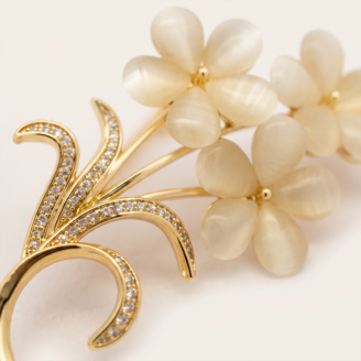 Broche flor olho de gato com zircônia banho ouro 18k hipoalergênico com acabamento de alto brilho.