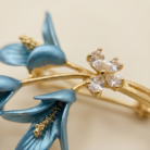 Broche buquê de lírio azul com zircônia banho ouro 18k hipoalergênico com acabamento de alto brilho.