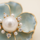 Broche flor azul com pérola banho ouro 18k hipoalergênico com acabamento de alto brilho.