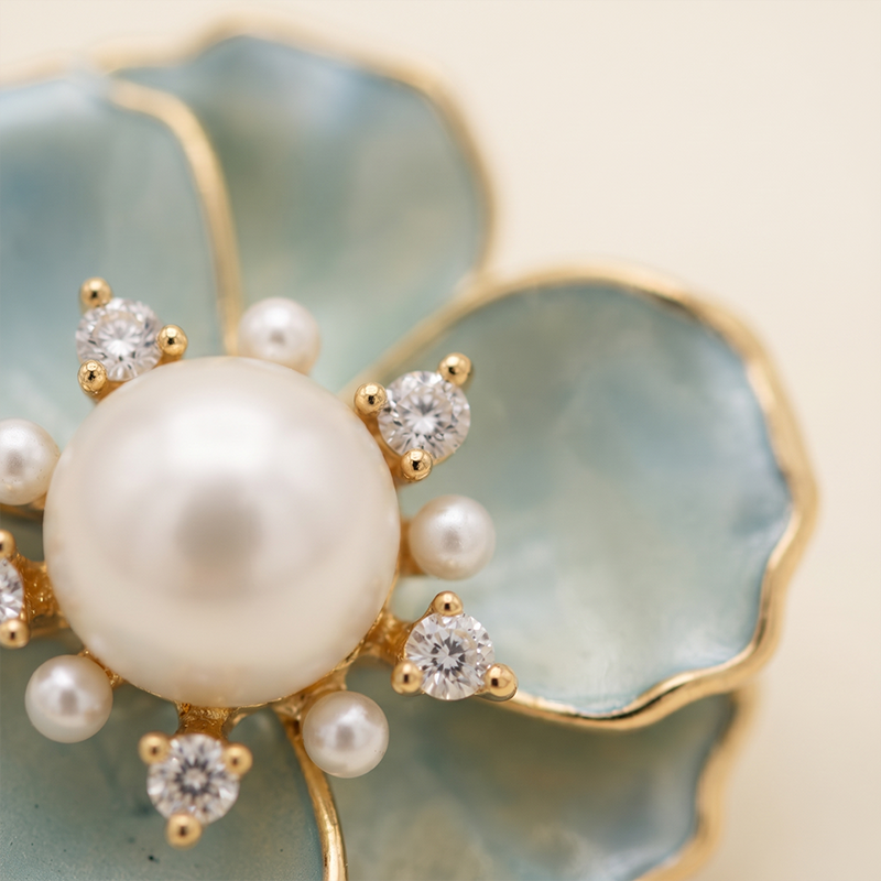 Broche flor azul com pérola banho ouro 18k Broche flor azul com pérola banho ouro 18k hipoalergênico com acabamento de alto brilho.